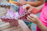 Kids' hands shown making tissue paper flowers